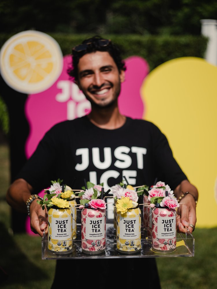 Gentleman holding tray of Just Ice Tea drinks