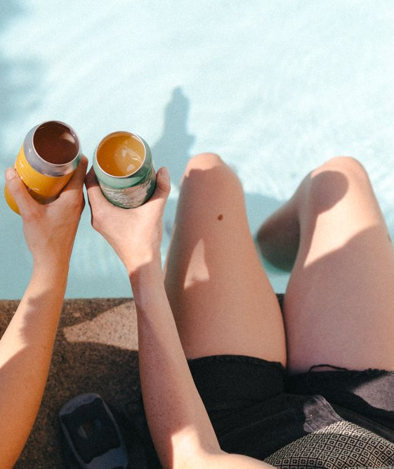 Two people cheering with two cans holding a Draft Top Lift